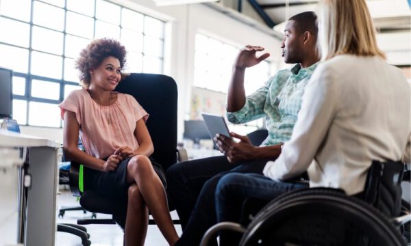 A Woman in Pink Sitting With a Man and a Woman